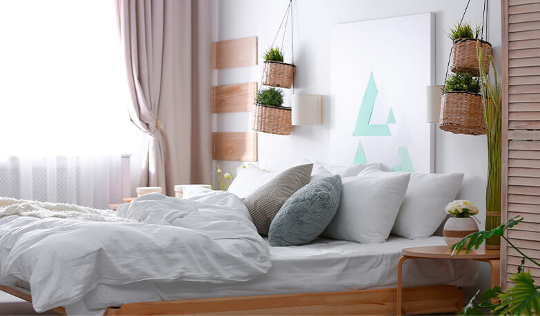 Neutral coloured bedroom with white bedding and wooden decorative elements
